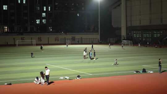 城市户外足球场市民晚上运动散步踢足球