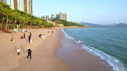 夕阳下美丽海滩边拍照的人群 海景别墅