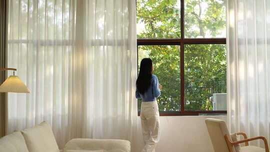 美女打开窗帘呼吸新鲜空气看窗外