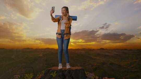 亚洲女性徒步旅行者的全身同时在山顶上自拍