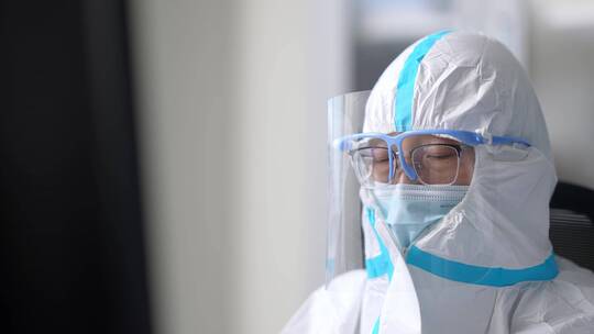 实验室防护服护目镜科研人员比对着试管工作