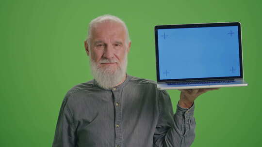 绿色屏幕一位拿着蓝色屏幕笔记本电脑的老人