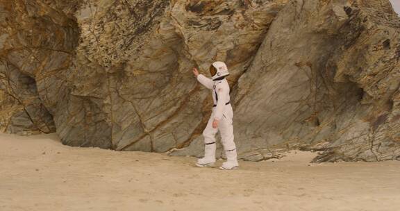 穿着太空服走在沙地上男孩