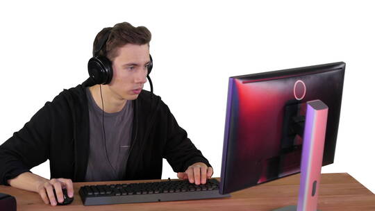 戴着耳机的人在电脑上玩电子游戏