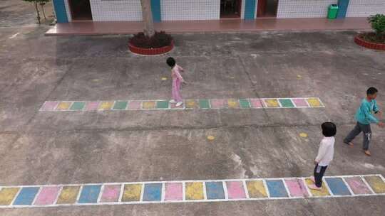 儿童在户外场地玩跳房子