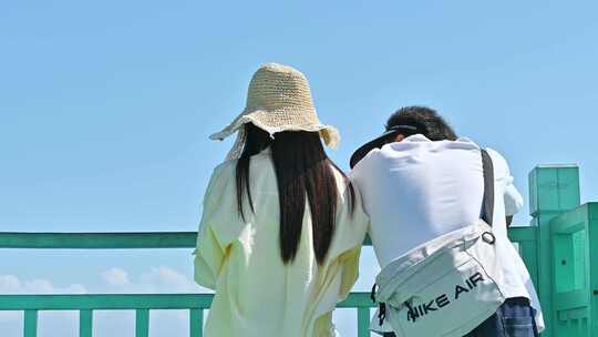 海南三亚海棠湾情侣在拍摄蔚蓝色海洋背影