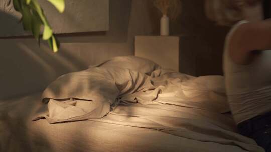 黎明时分，一个女人倒在舒适的床上，这是一视频素材模板下载