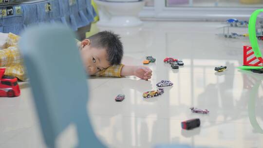 地板上玩玩具汽车的小男孩视频素材模板下载
