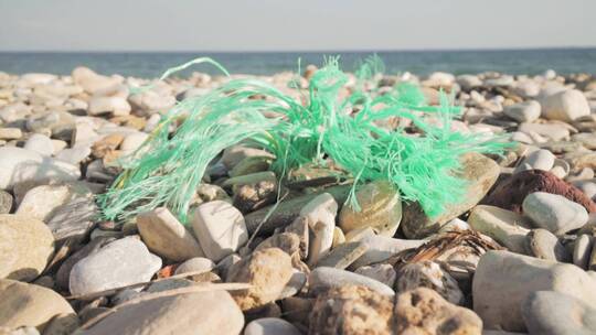 沙滩上的卵石和塑料绳子