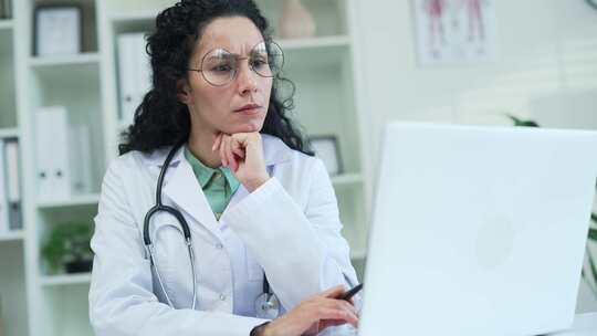 特写。一位严肃的女医生正在使用，坐在工作视频素材模板下载