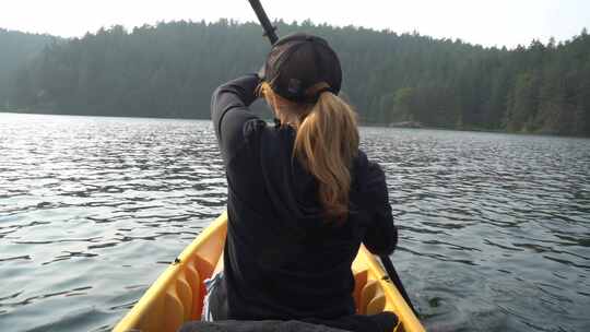 日落时独自在湖上划独木舟的女人视频素材模板下载