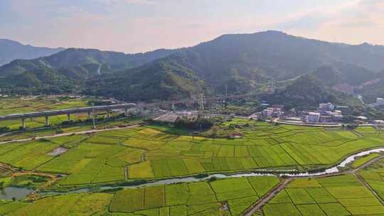 高铁行驶在绿意盎然的山间田野上