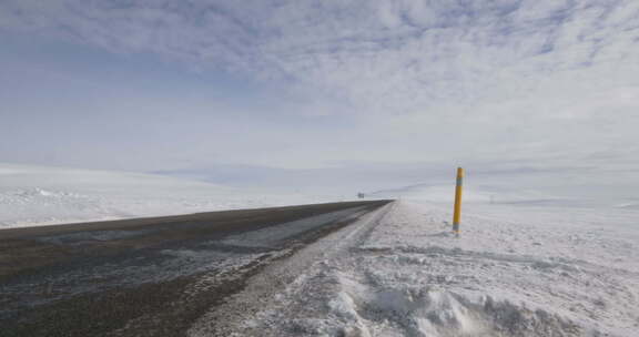 冰天雪地公路上一辆车驶过