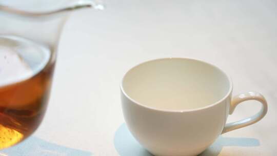 玻璃水壶往陶瓷茶杯倒茶视频素材模板下载