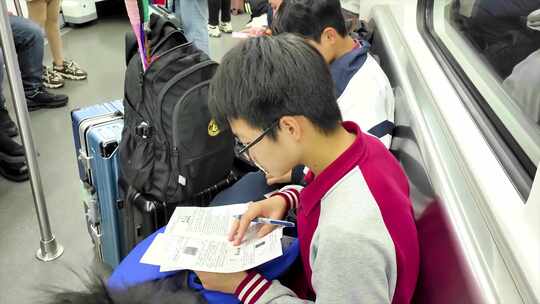 男孩在地铁上写作业 看书