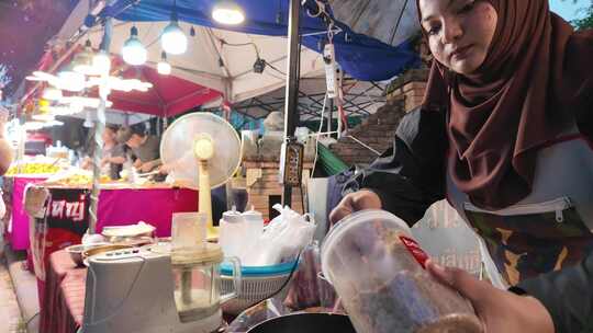 泰国清迈夜市摊位上的女性在准备食材