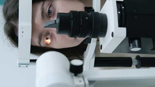 细心的验光师在眼科诊所用裂隙灯检查美丽的