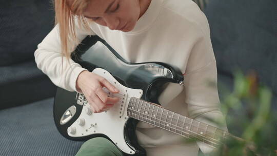学习弹电吉他的女人视频素材模板下载