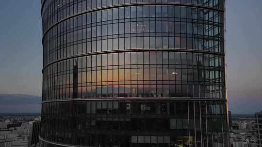 4K-黄昏时分的圆形办公大楼玻璃幕墙视频素材模板下载