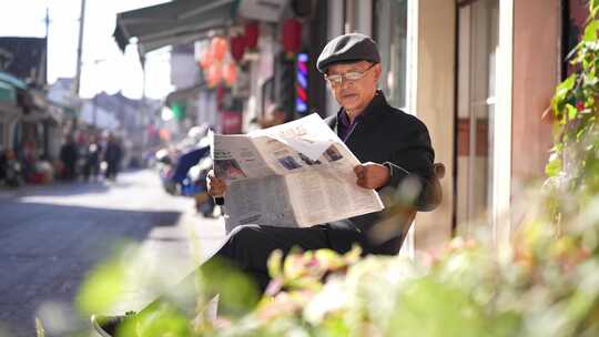老年人阳光下看报纸
