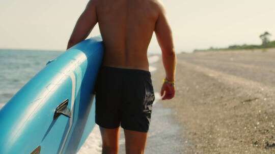 沙滩边抱着冲浪板的人视频素材模板下载