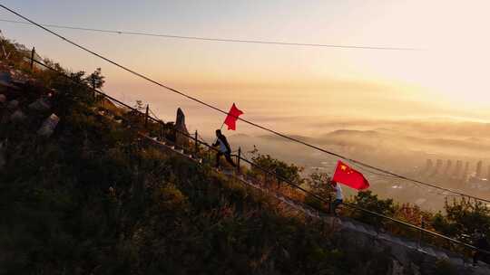 在山顶迎着朝霞日出挥舞国旗