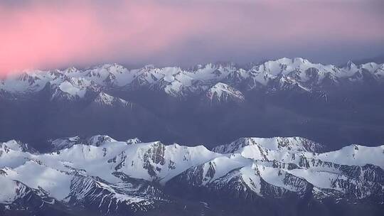 白雪皑皑的山脉上的粉红色云彩