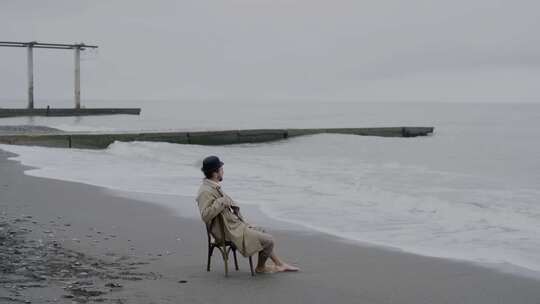 男人独自坐在椅子上在沙滩上