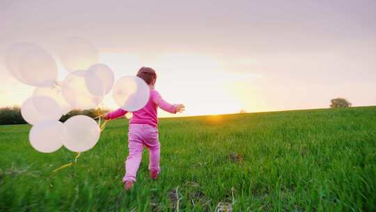 在阳光明媚的草地上女孩拿着气球奔跑