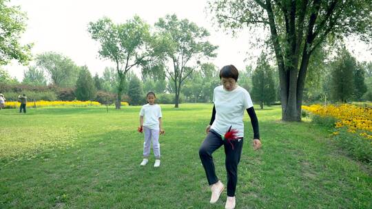 夏天在公园一起玩踢毽子游戏的中国母女