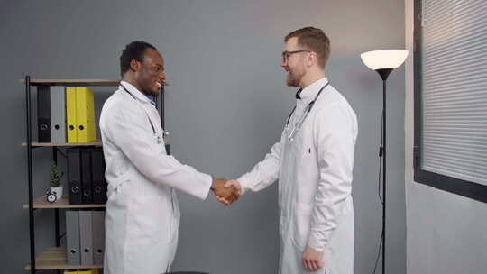 两个穿着白大褂的医生在握手