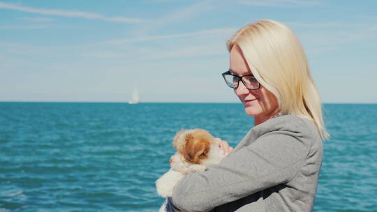海边爱抚小狗的女人