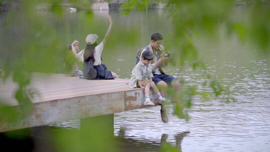 快乐家庭坐在湖边玩耍