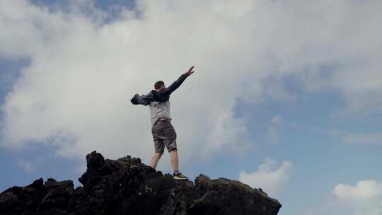 站在悬崖上举手感受自由和享受自然的人