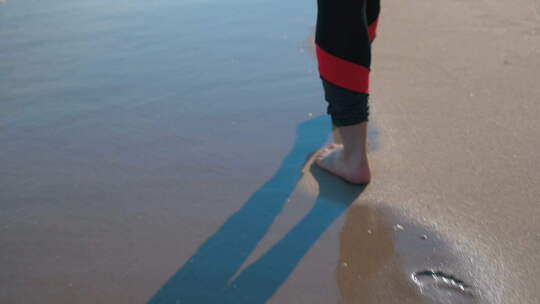 沙滩上的赤脚行走的人