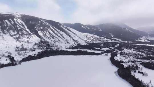 航拍新疆冬季喀纳斯湖雪景雪山森林冰河晨雾