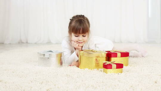 女孩趴在地毯上打开礼物视频素材模板下载
