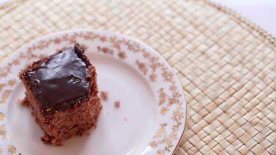 在盘子里用勺子吃一片巧克力蛋糕