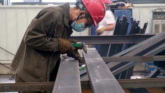 钢铁工厂的车间内工人操作角磨机打磨钢材视频素材模板下载