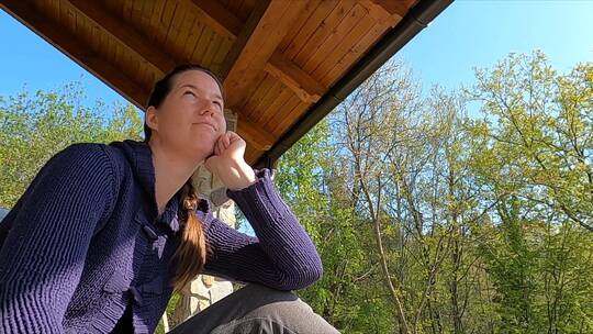 一个从阳台上欣赏森林景色的女人
