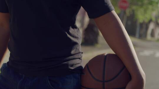 抱着篮球微笑的阳光男孩