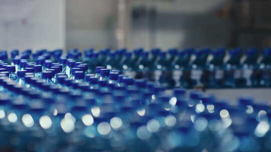 无数行瓶装泉水在工厂的传送带上移动