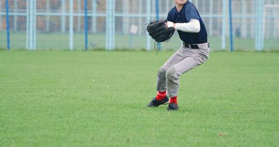 学校棒球锦标赛男孩投手奔跑并成功地在手套里接住了一个快球
