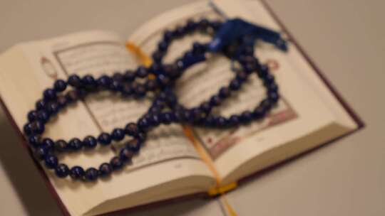 桌面上的古兰经和祈祷珠