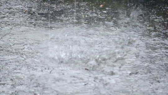 大雨滴落在沥青上的雨滴