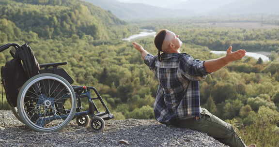 残疾人的肖像，坐在山顶轮椅附近