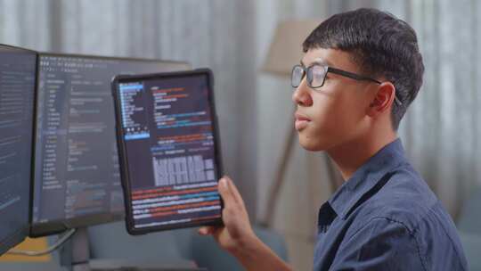 亚洲男孩程序员在创建软件工程师开发应用程序时查看平板电脑上的数据库