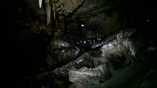 人们用手电筒探索黑暗的洞穴视频素材模板下载