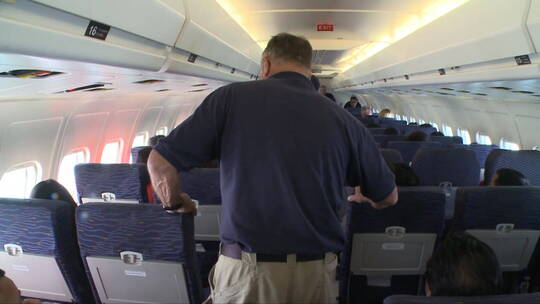 工作人员在飞机上检查乘客