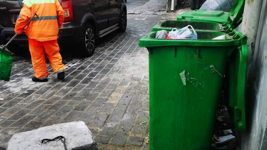 垃圾桶旁工作的环卫工人在清扫